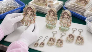 オリジナルIPのアクリルグッズを白手袋で目視検品する中国工場の品質管理イメージ