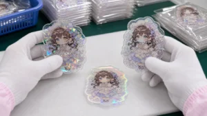 ホログラム、ラメ、オーロラのアクリルサンプルを白手袋で比較するイメージ