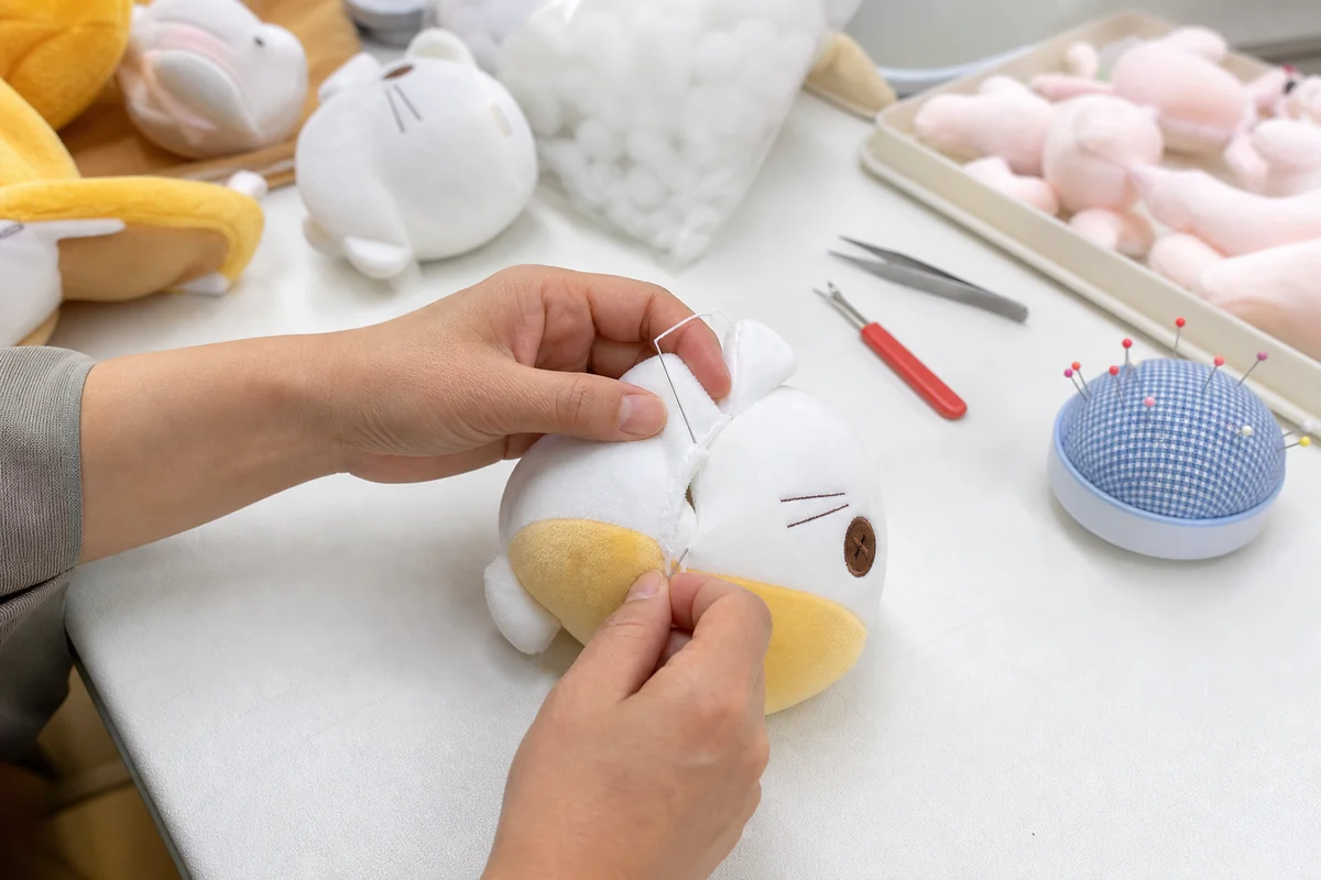 ぬいぐるみの開口部を手縫いで仕上げる工程
