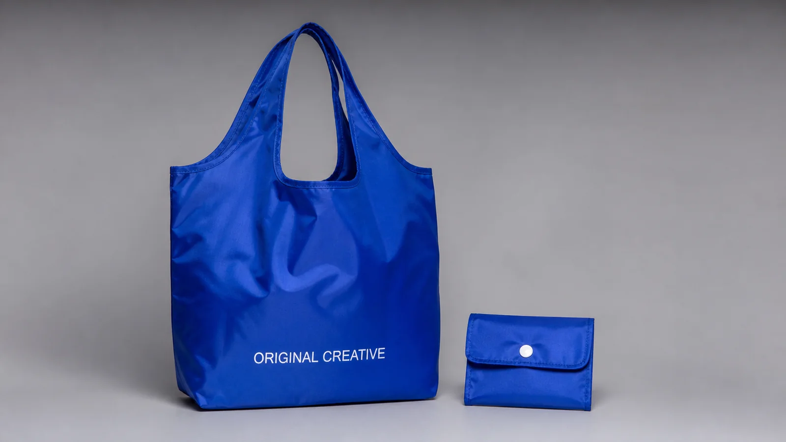 Royal-blue foldable shopping bag with white logo print and matching flat snap pouch