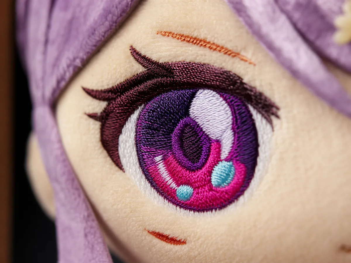 Macro view of a glossy satin stitch embroidered plush eye on beige short-pile velboa