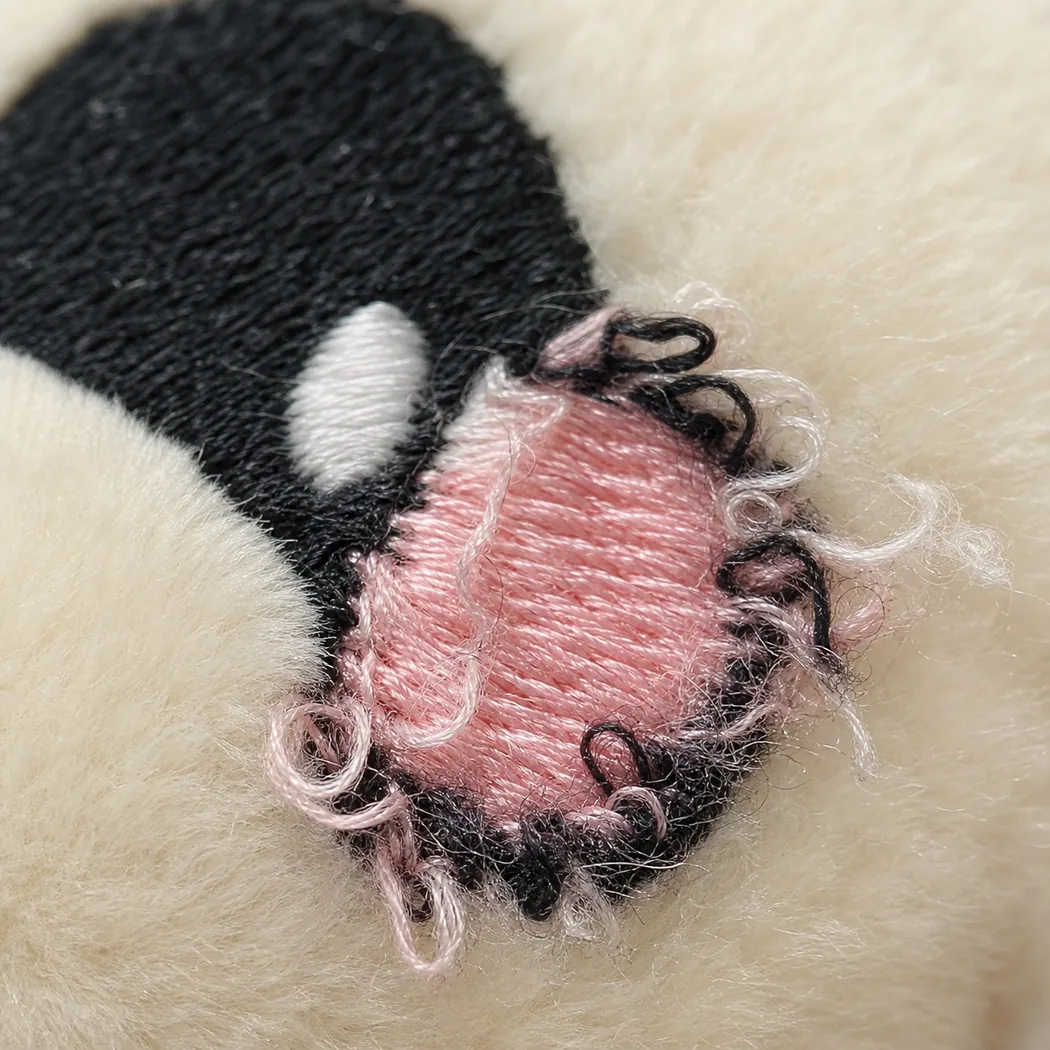 macro view of defective plush embroidery with loose looping threads