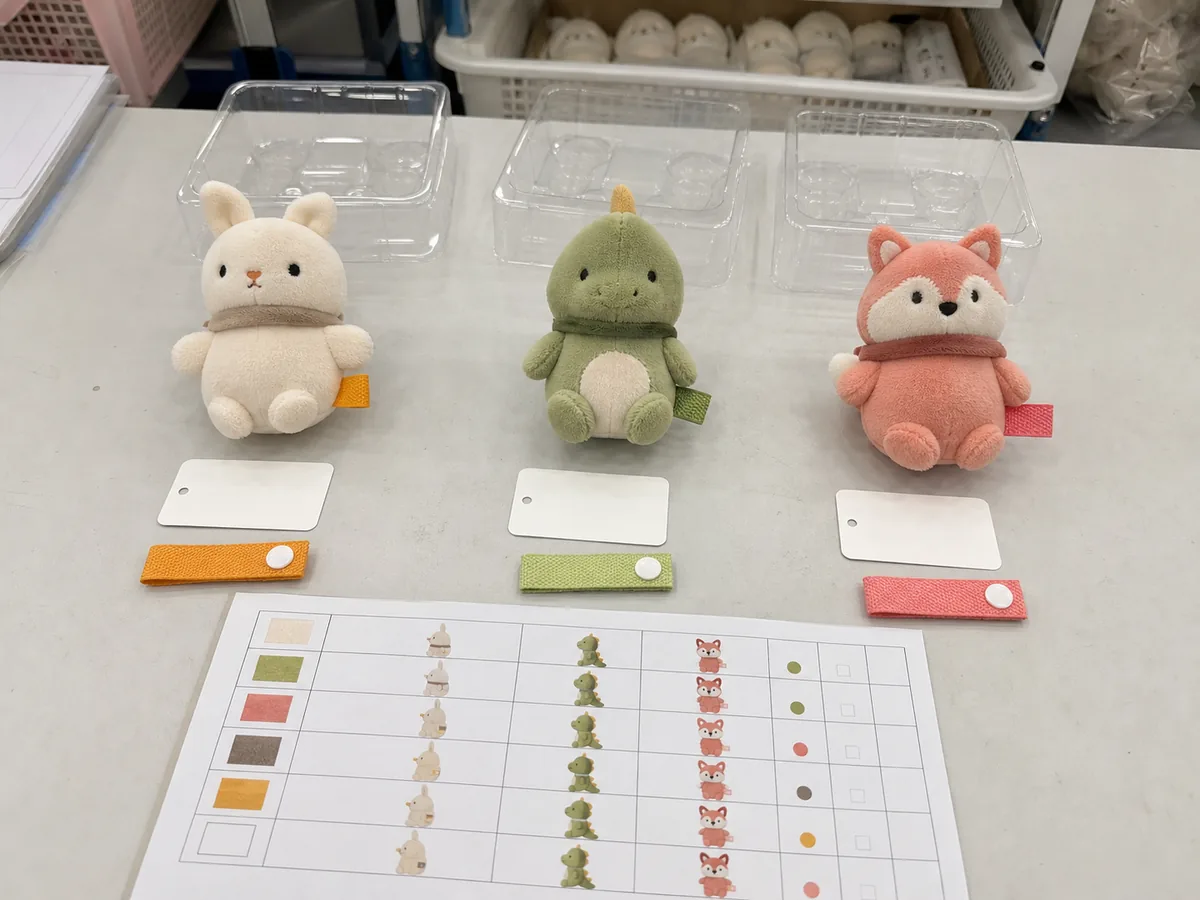 three custom plush SKUs grouped with tags, labels and packing trays