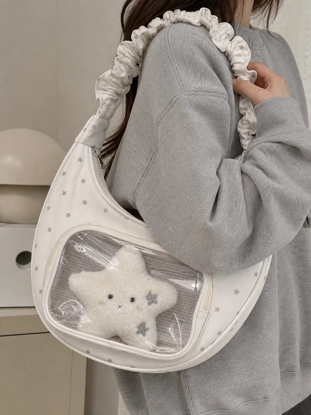 星柄の白い半月ショルダー痛バッグに透明窓と星形ぬいぐるみを入れた着用シーン