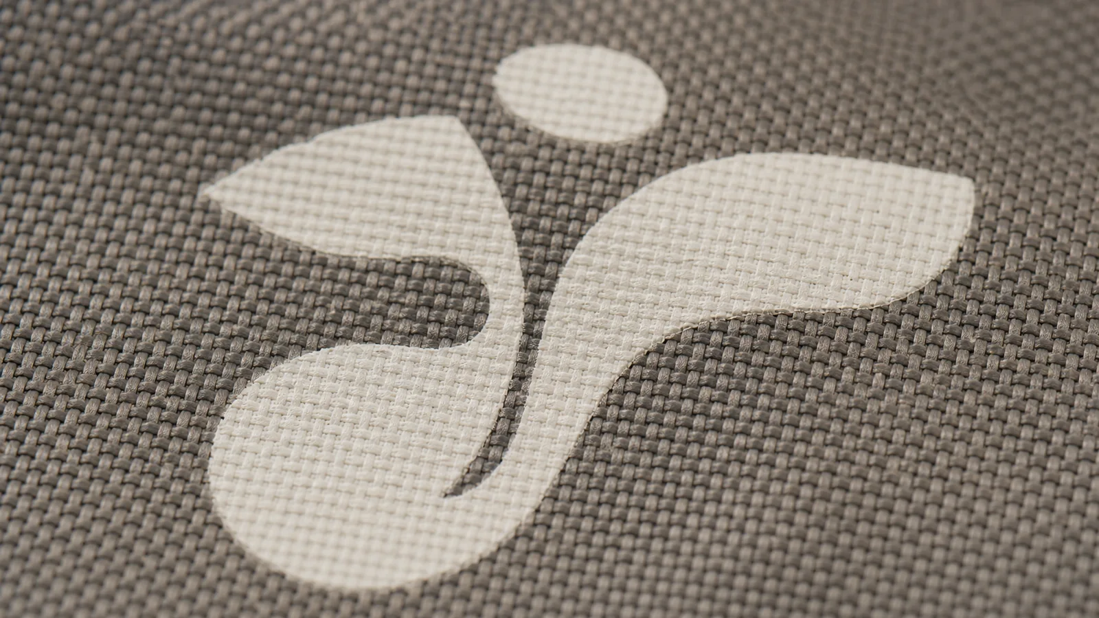 Macro photo of a white eco icon printed on grey RPET fabric with water-based ink