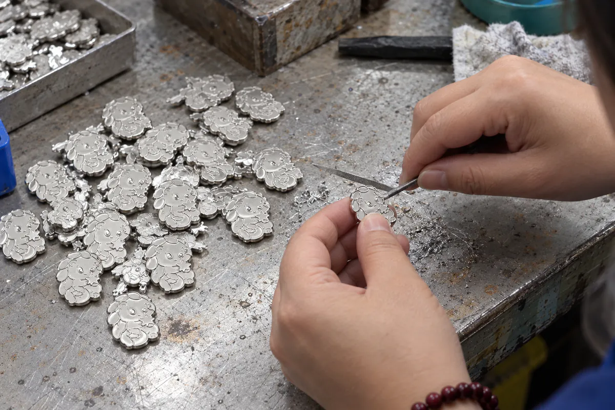 動画の手作業カットを基に月莓穿山甲の銀色金属素地からバリを除去する工程