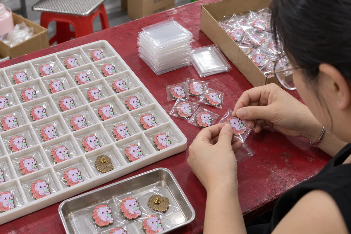 動画の品検包装カットを基に月莓穿山甲ピンバッジを個別保護して包装する工程